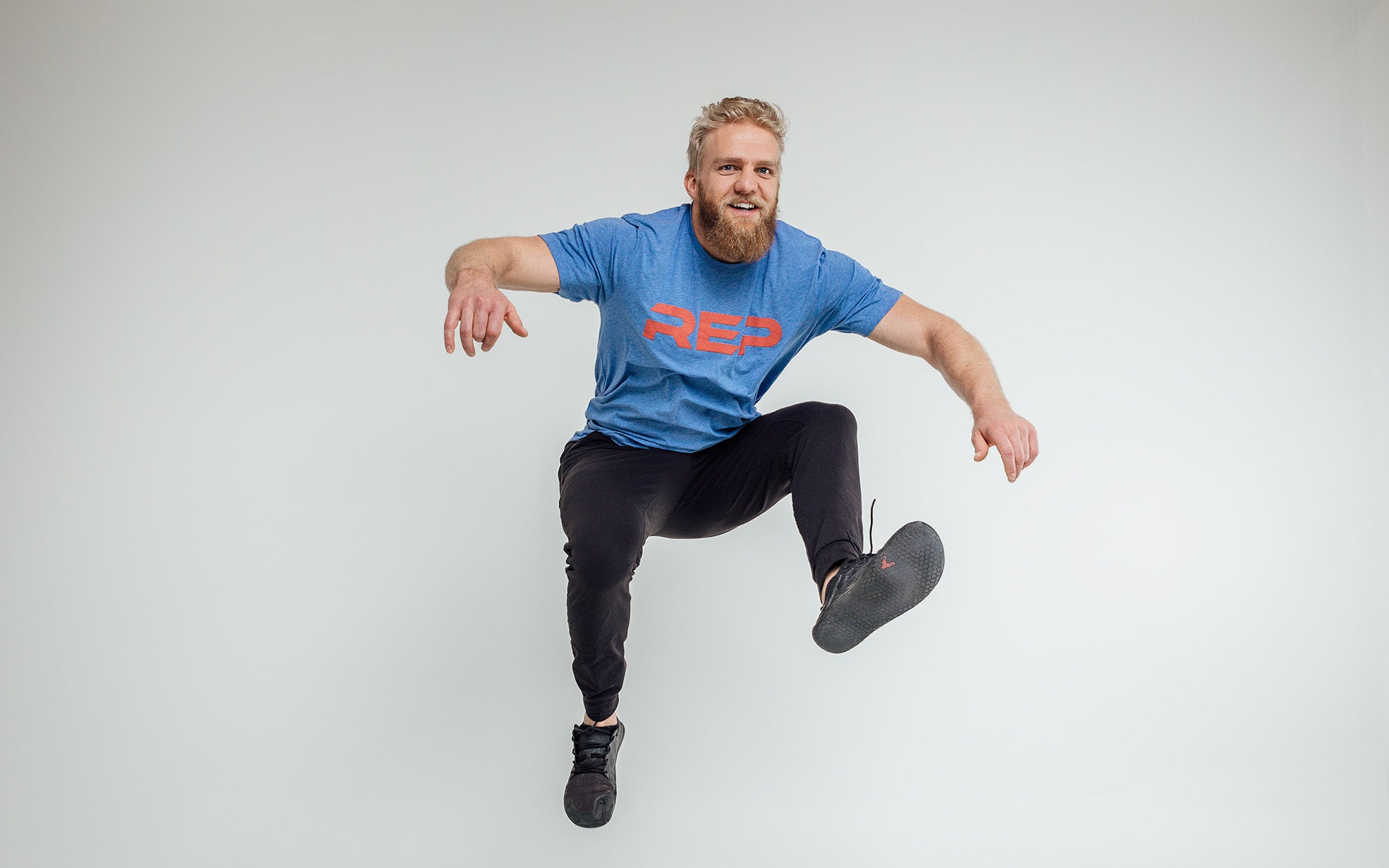 Guy jumping in blue daily driver shirt