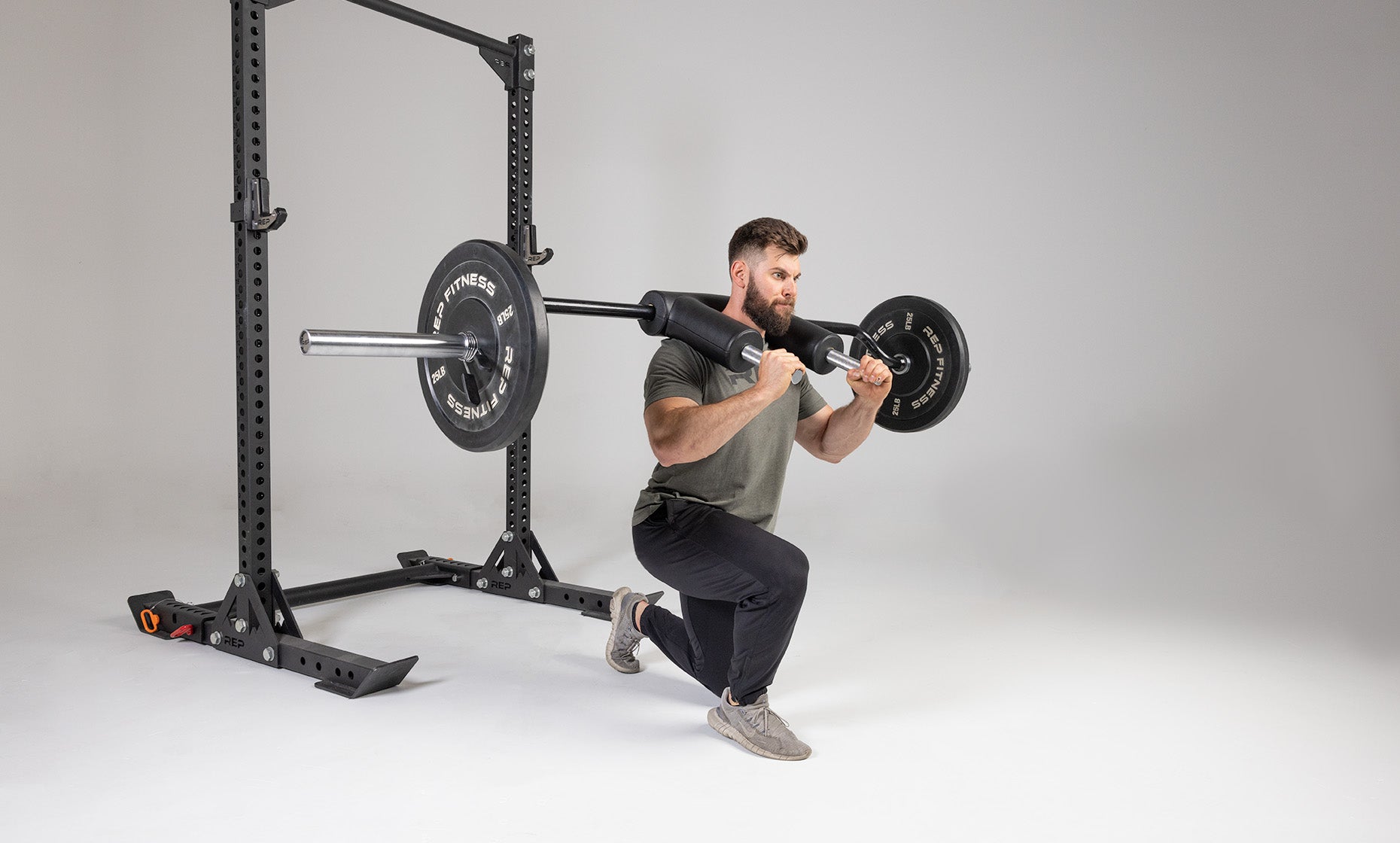 Lifter performing a lunge with a weighted Safety Squat Bar.