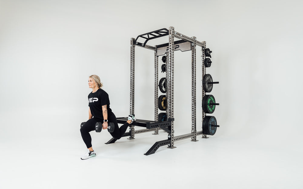 Utility Seat Installed on Spotter Arms on Power Rack Being Used For Bulgarian Split Squats