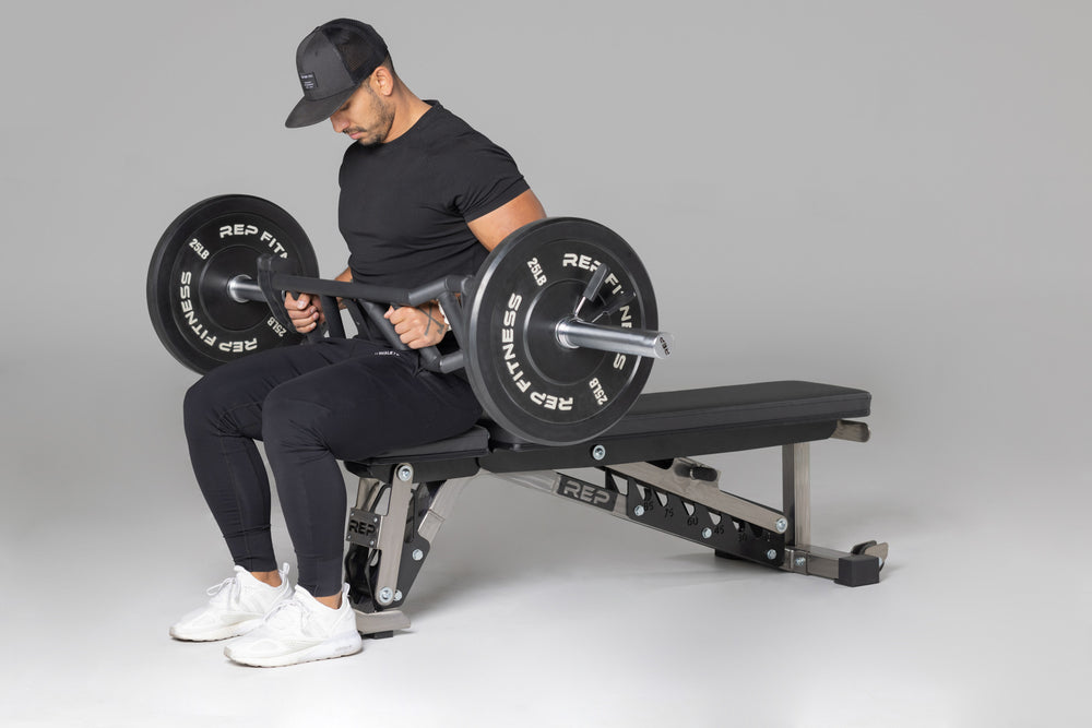 Lifter preparing to use loaded Cambered Swiss Bar for flat bench press.