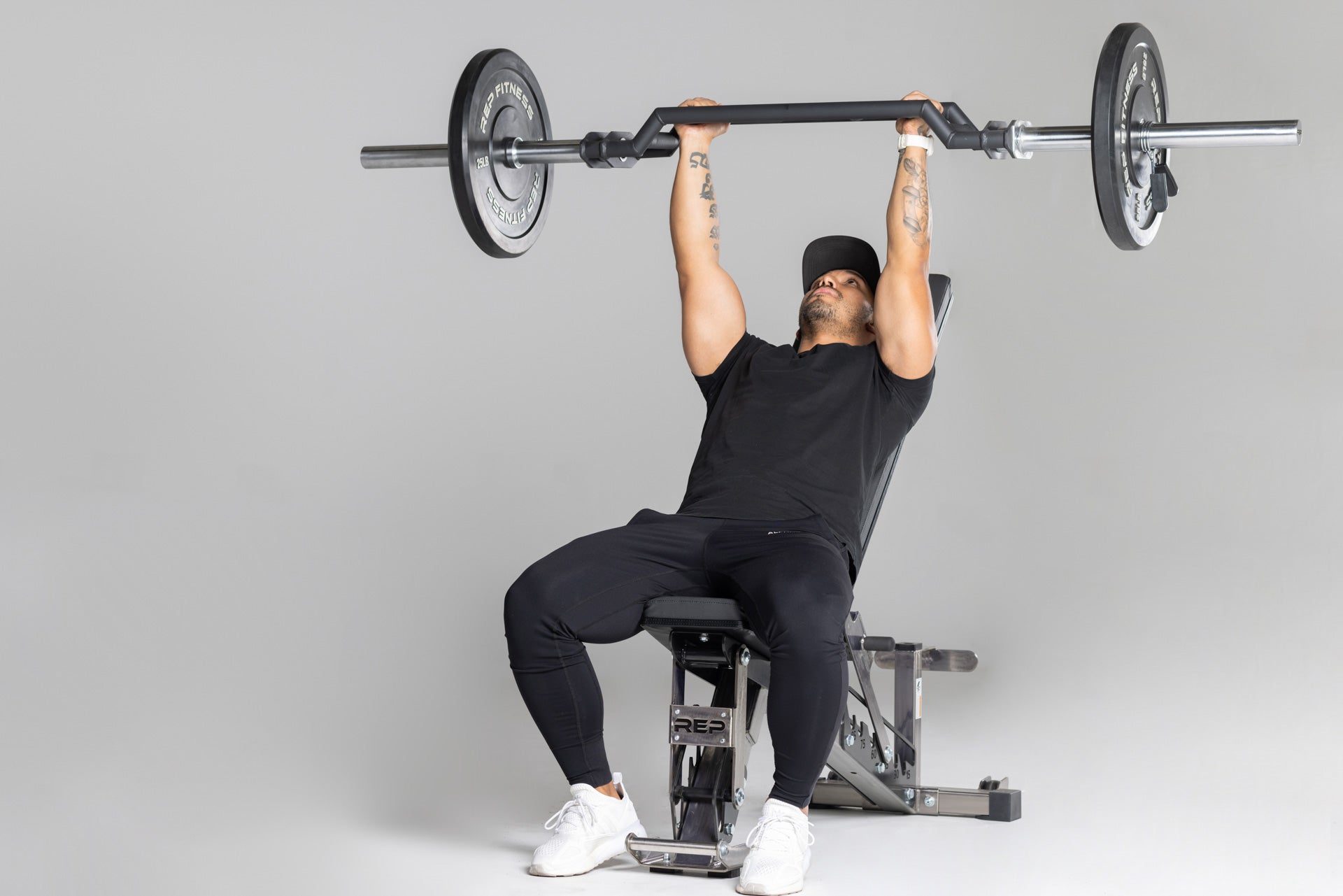 Lifter using loaded Cambered Swiss Bar for incline bench press.