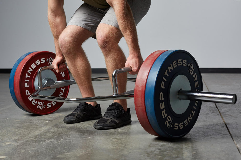 Lifter at the bottom of a deadlift using a loaded Trap Bar.