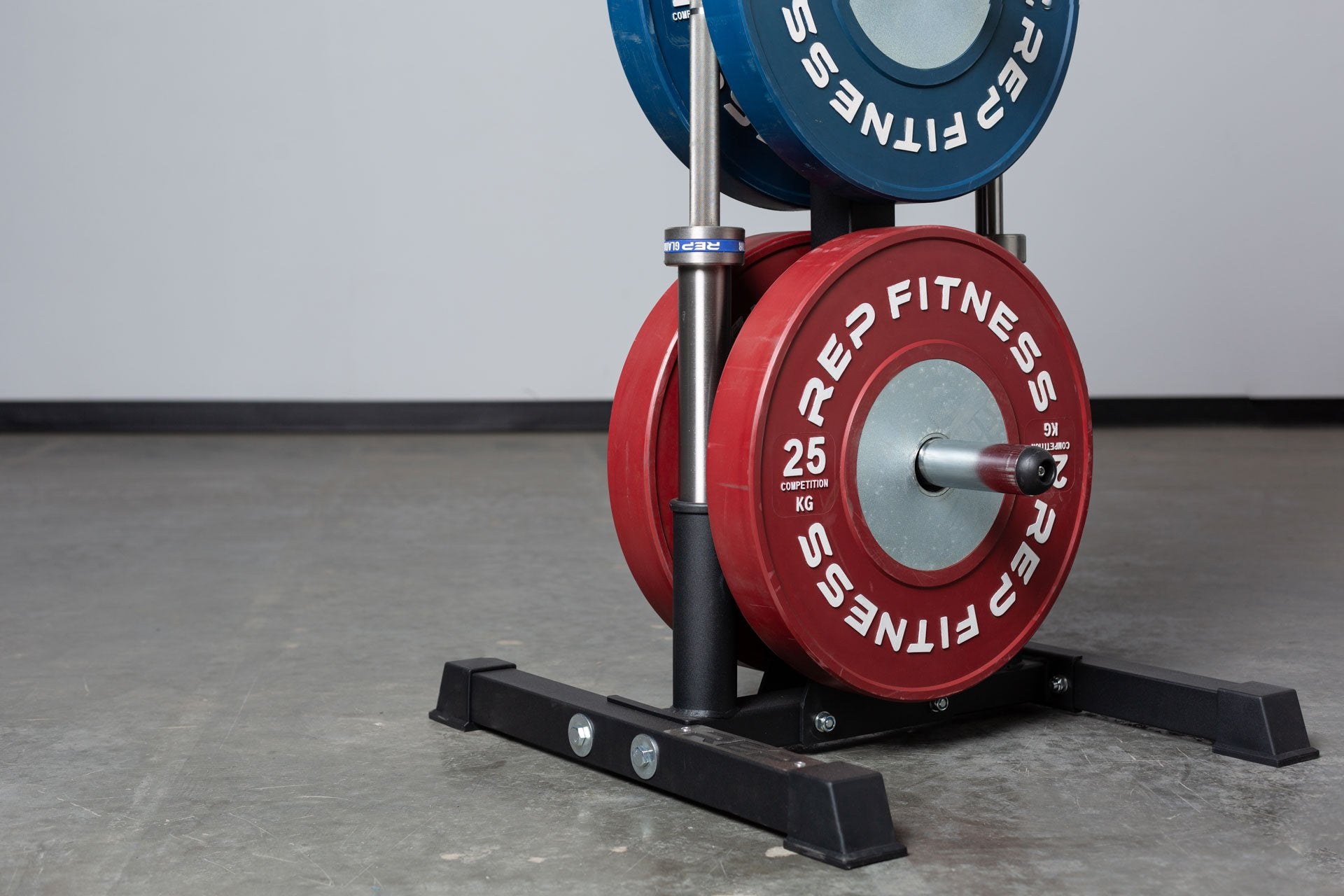 Close-up view of the bottom section of the REP Bar and Weight Plate Tree loaded with a pair of 25kg REP Competition Bumper Plates and two barbells.