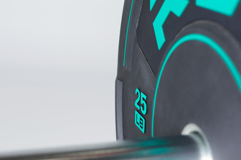 Close-up view of the green "25 LB" weight marking on a 25lb sport bumper plate loaded on a barbell.