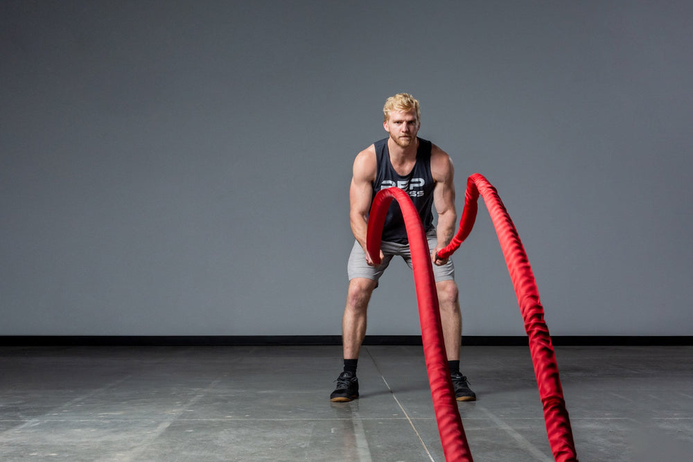 Exercising with red Battle Ropes