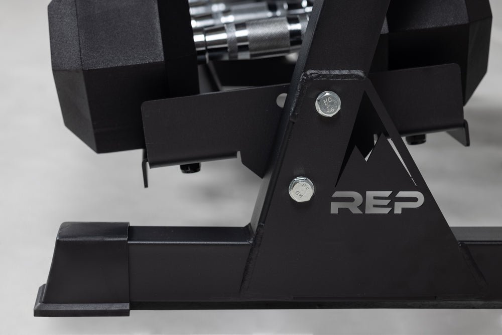 Close-up side view of the bottom of a REP Dumbbell Rack storing a set of Ergo Hex Dumbbells.