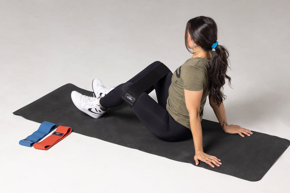 Lifter performing seated hip abductors using the black medium resistance REP circle hip band.