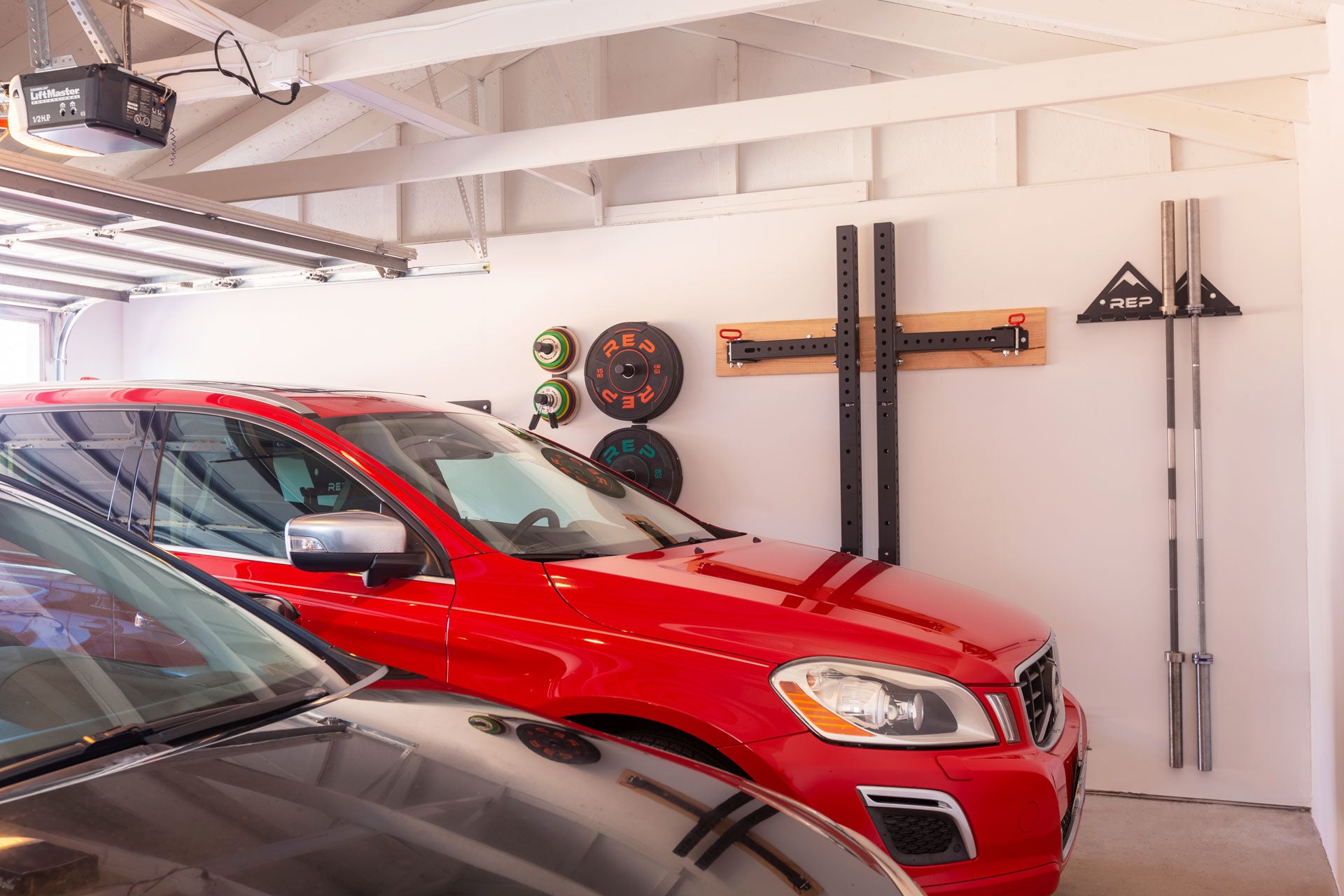 A garage with two parked cars showcasing REP's space-saving storage options including the REP Multi-Use Wall Storage.