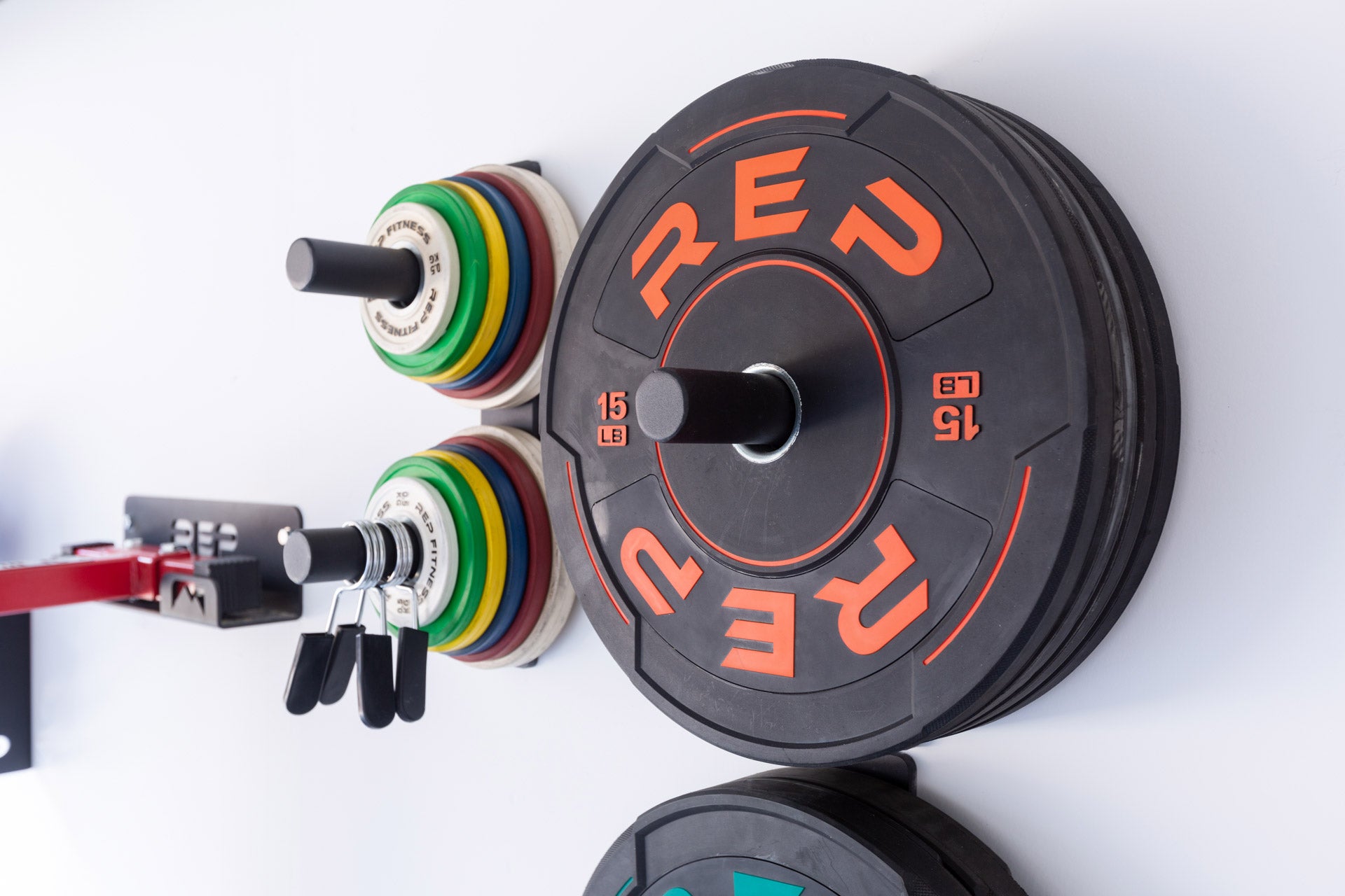 Single and double Wall Mounted Plate Storage loaded with bumper plates and change plates.