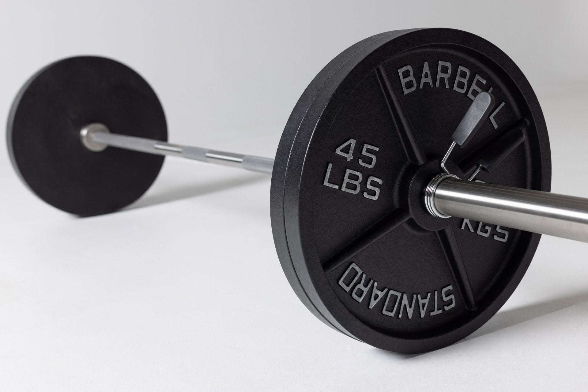 Barbell loaded with two pairs of 45lb Old School Iron Plates and spring clips.